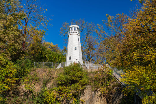White structure of the Mark Twain Memorial lighthouse on a bluff above Hannibal in Missouri by Mississippi River