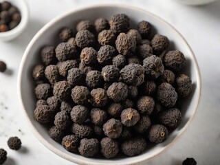 Pimienta en grano en tazón sobre una mesa blanca 