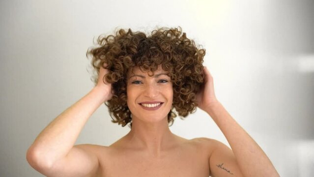 Attractive young female playing with her hands in her curly afro hair
