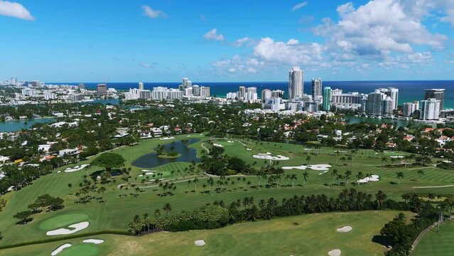 Aerial view of magnificent La Gorce Club near ocean waterfront. Exclusive resort in Florida with large golf course and modern multi-storey buildings on background