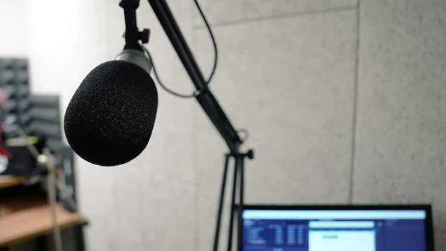 Recording studio, microphone close-up. Podcast recording, radio, dubbing, audio track. A small room with musical equipment, a computer monitor
