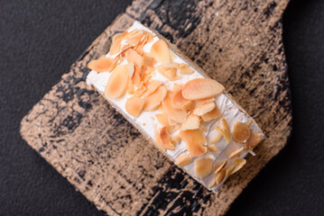 A piece of delicious sweet meringue roll with mascarpone cheese, berries and almonds