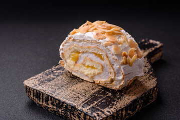 A piece of delicious sweet meringue roll with mascarpone cheese, berries and almonds
