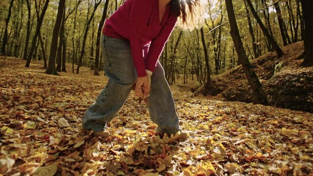 Embracing Nature: Cheerful European Woman Enjoying Fall, Surrounded by Vibrant Leaves. High quality 4k footage