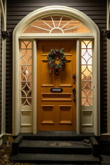 A yellow wooden country-style door with an arched window over the entrance. There are two glass...