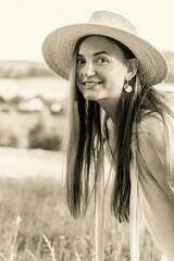 Portrait of a young beautiful woman in a straw hat outdoors