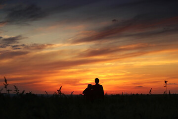 Mother and adult son silhouette in the summer meadow on a sunset background. Sunset 10 August 2023 year, msk time. - 680694916