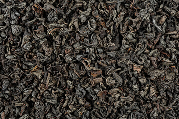 Background of dry black tea leaves, top view. Dried black tea as background. - obrazy, fototapety, plakaty