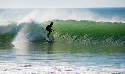Surfer in action in the tubular waves of the Atlantic Ocean - obrazy, fototapety, plakaty