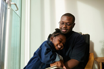 Fototapeta premium Toddler hugging her loving father when she is excited about getting something right