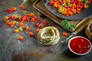 Raw pasta, spaghetti in a plate with seasonings and vegetables. Raw, ready-to-cook dish.