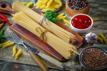 Raw pasta, spaghetti in a plate with seasonings and vegetables. Raw, ready-to-cook dish.