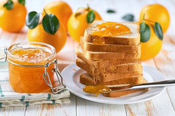 A stack of toasts with orange jam on a dish close-up. Plate with pieces of toasted bread and  tasty...