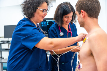 Cardiologist placing electrodes on a patient for a stress test - obrazy, fototapety, plakaty
