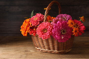 Fototapeta na wymiar Beautiful wild flowers in wicker basket on wooden table