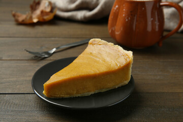 Piece of delicious pumpkin pie on wooden table, closeup