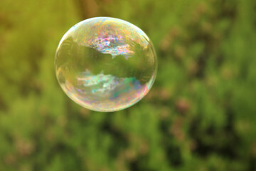 One beautiful clear soap bubble floating outdoors