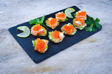 Traditionelle Pumpernickel Taler mit Räucherlachs und Kaviar serviert als Häppchen auch einem Design Tablett 