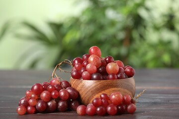 Delicious fresh red grapes on dark wooden table