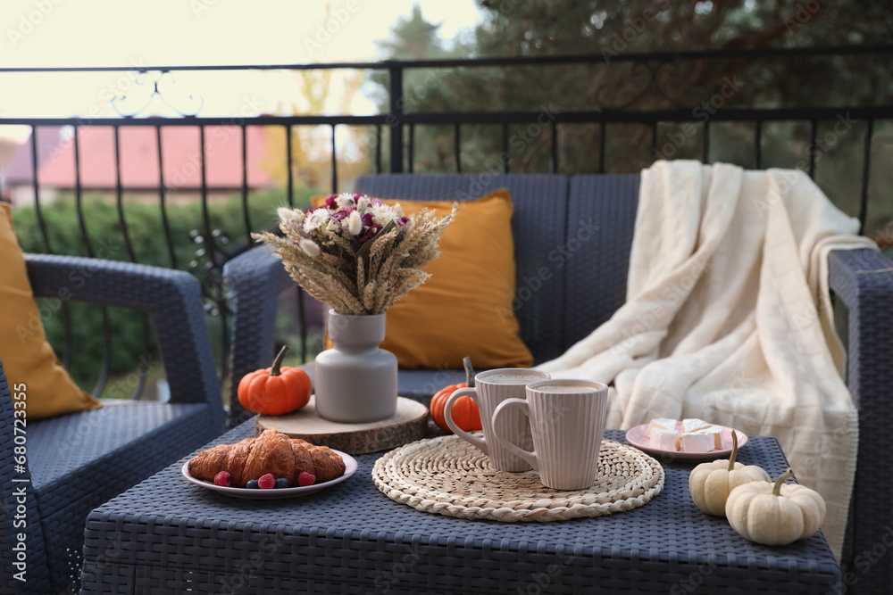 Canvas Prints Rest on terrace with rattan furniture. Drink, dessert and autumn decor on table