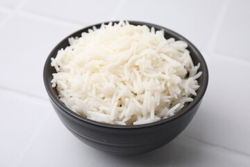 Bowl of delicious rice on white table, closeup