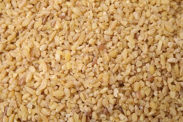 Uncooked organic bulgur as background, top view