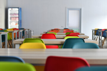 Colorful chairs in the empty school dining room. Selective focus. - obrazy, fototapety, plakaty