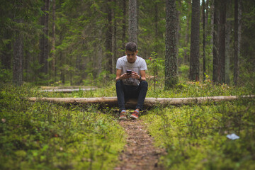 A person sitting among trees in a lush green forest.