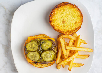 cheese burger top with pickles and relish  served with fries