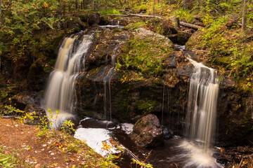 Fototapeta na wymiar Two Waterfalls On A Creek In The Woods During Autumn