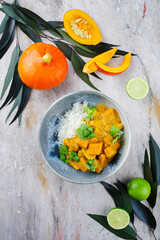 Traditional Indian vegetarian curry stew with sweet potatoes, pumpkin and rice served as top view in in a Nordic design plate
