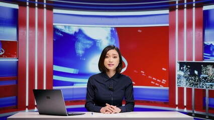Asian presenter hosting news segment on live program, addressing all headlines in newsroom. Woman...