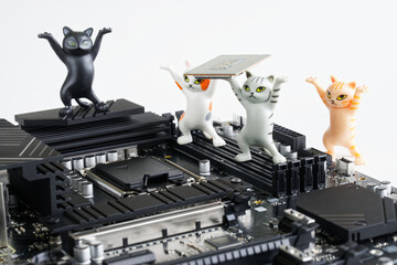Cute toy kittens mount a computer processor into a socket on the motherboard. Study of computer...