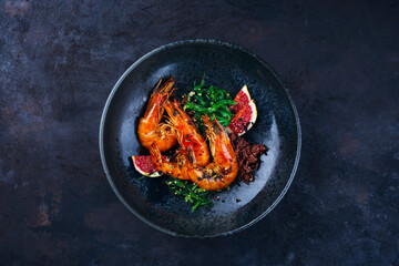 Traditional fried king prawns with fig pieces, brown rice and wakame served as top view on a design bowl with text space - obrazy, fototapety, plakaty
