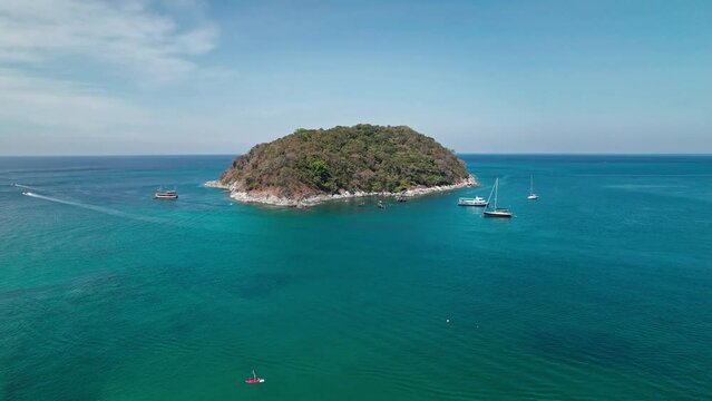 A small natural rocky island snorkelling spot near Yanui beach at Phuket island, Thailand. Aerial drone footage 4k vibrant in sunny weather