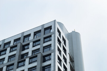 Part of the facade of a modern building against a cloudy sky