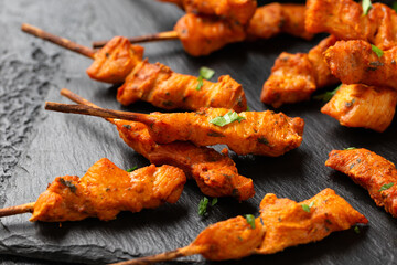 Grilled chicken fillet on skewers with white sauce on rustic stone board