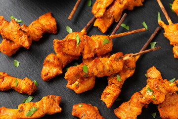 Grilled chicken fillet on skewers with white sauce on rustic stone board