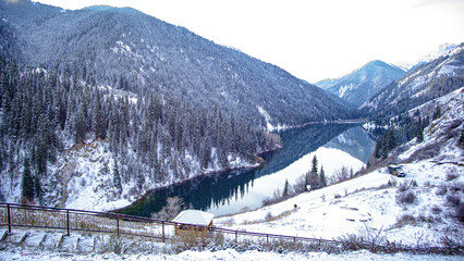 snow covered mountains with lake reflection