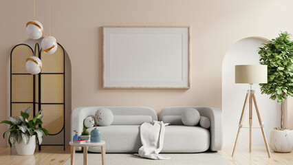 Poster mockup with vertical frame on empty white wall in living room interior with gray sofa
