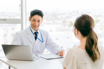 Fototapeta premium 診察・診療・問診・カウンセリングをする医者・医師・ドクターの男性と女性 