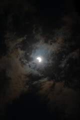 Dark landscape background of cloudy sky with solar eclipse in the center