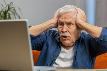 Displeased senior man use laptop notebook typing browsing working, loses becoming surprised scream by sudden lottery results bad news fortune loss game fail computer virus. Elderly grandfather at home