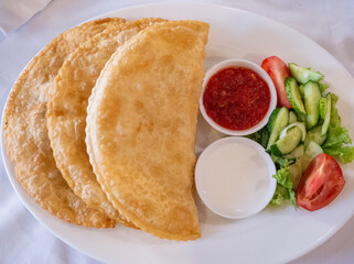 meat pies and salad on the white plate in tatar restaurant in capital kyiv