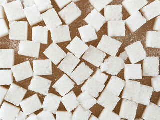 white sugar cubes on a wooden surface, background