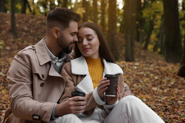 Happy young couple spending time together in autumn park