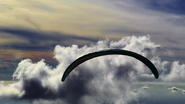 Close Up on a Paraglider Flying over Beautiful Cloudscape and Mountainscape with Sunlight in a Sunny Day in Ticino, Switzerland, Europe