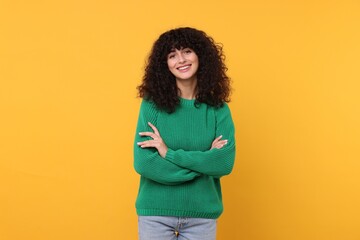 Happy young woman in stylish green sweater on yellow background - obrazy, fototapety, plakaty