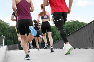 Fototapeta premium Group of people running outdoors, back view