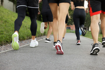 Fototapeta premium Group of people running outdoors, closeup view